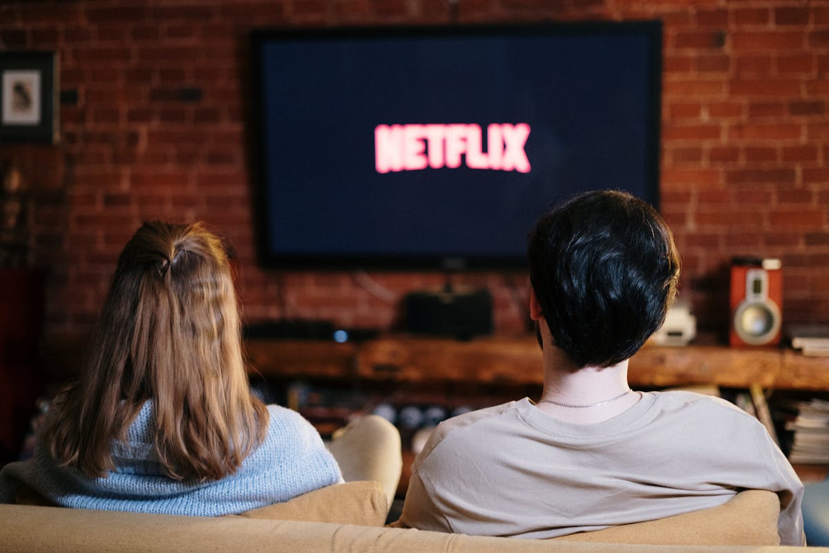 uomo e donna guardano tv con netflix