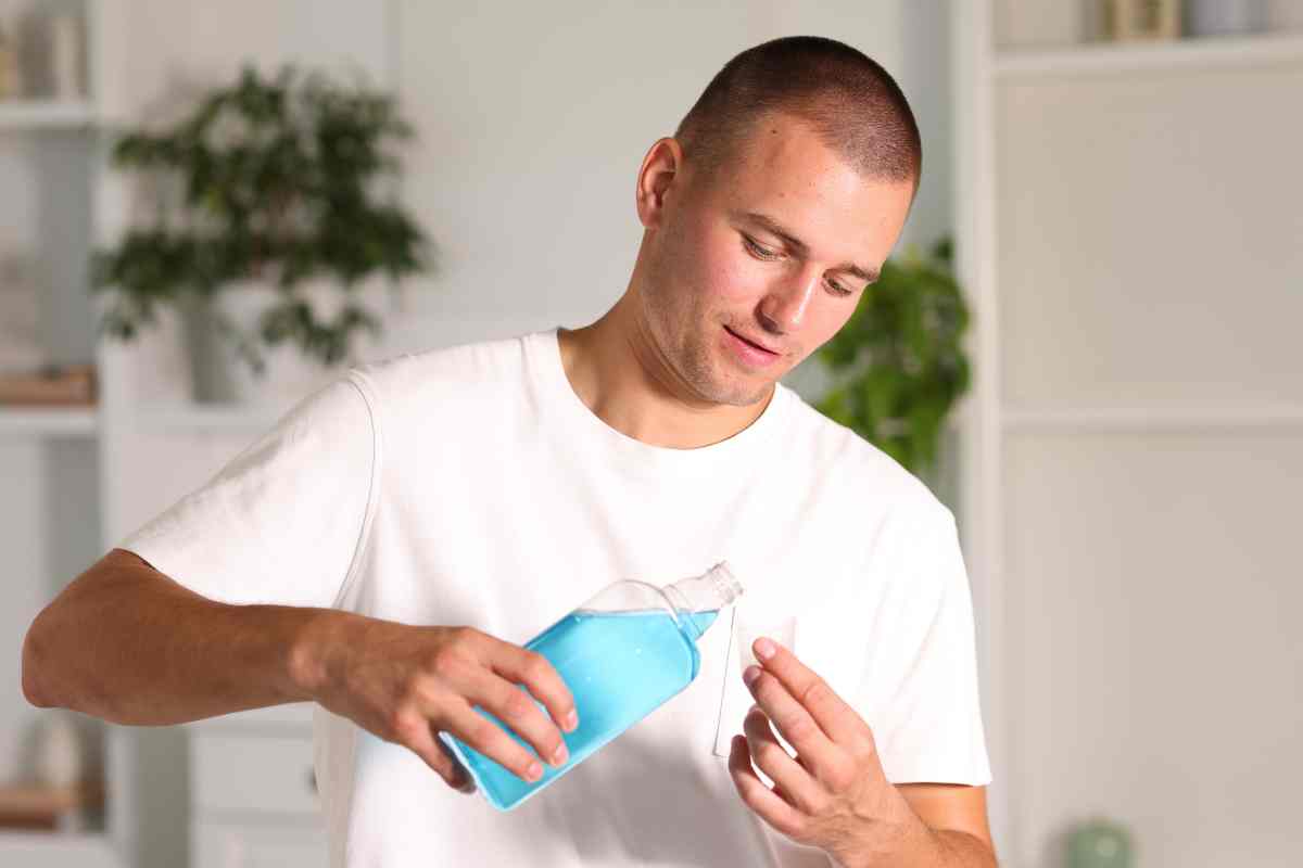 uomo usa il colluttorio