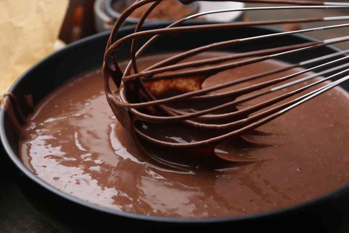 cioccolato fuso in una ciotola e una frusta