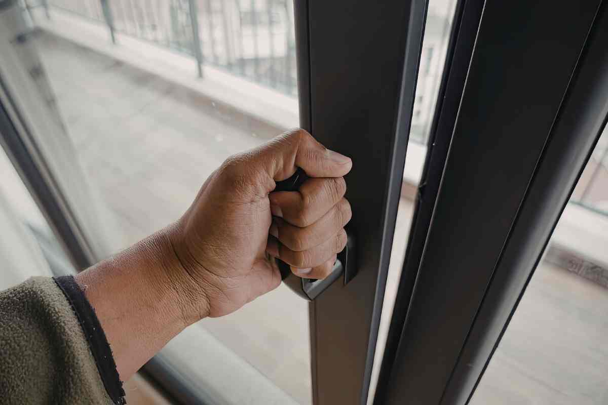 una mano apre infissi finestre