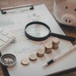 carta penna, calcolatrice, soldi e salvadanaio