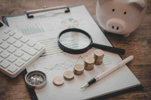 carta penna, calcolatrice, soldi e salvadanaio