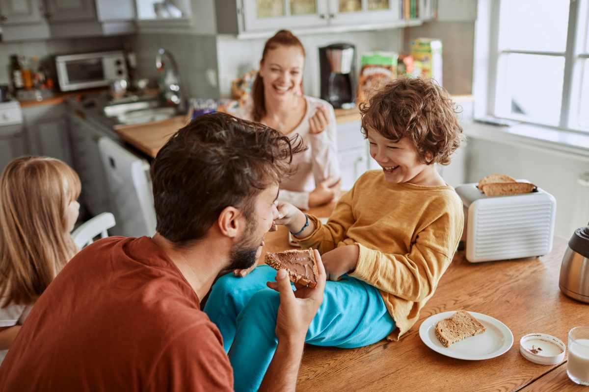 famiglia felice mentre fa colazione