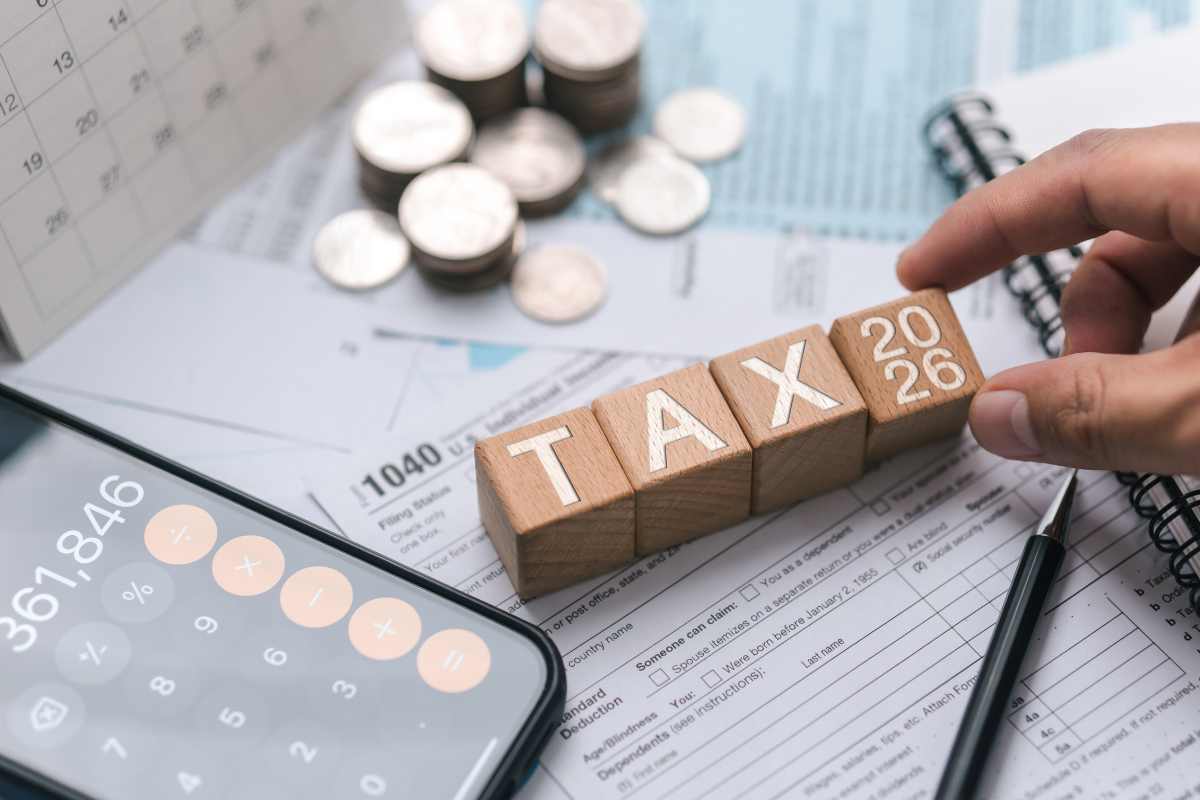 scritta tasse, calcolatrice e soldi 