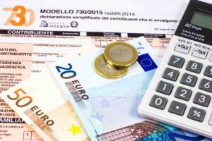 modello 730, calcolatrice e soldi con spiccioli