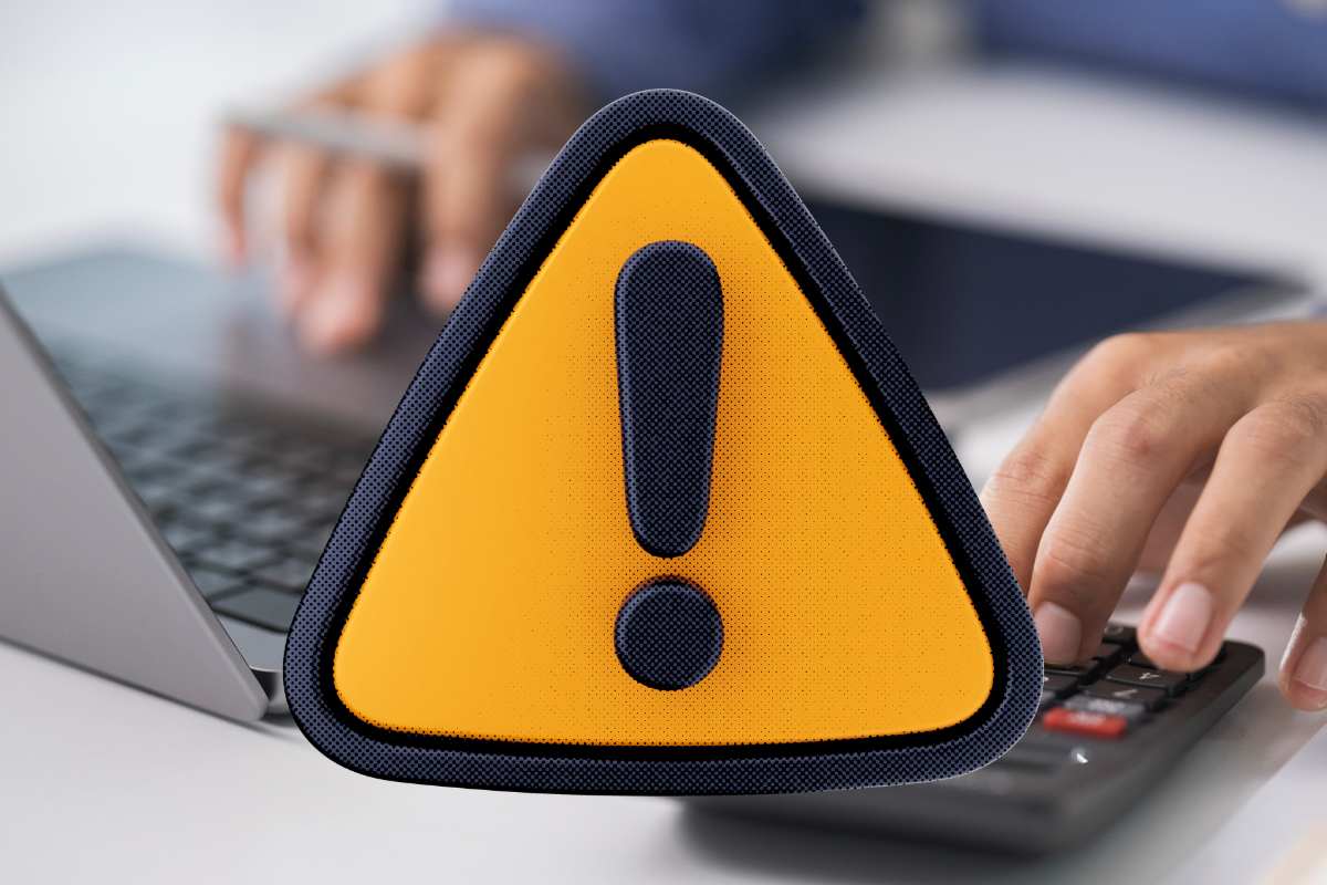 uomo al pc con calcolatrice e simbolo divieto giallo