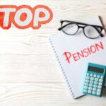 pensione, calcolatrice, salvadanaio a forma di maialino e scritta stop