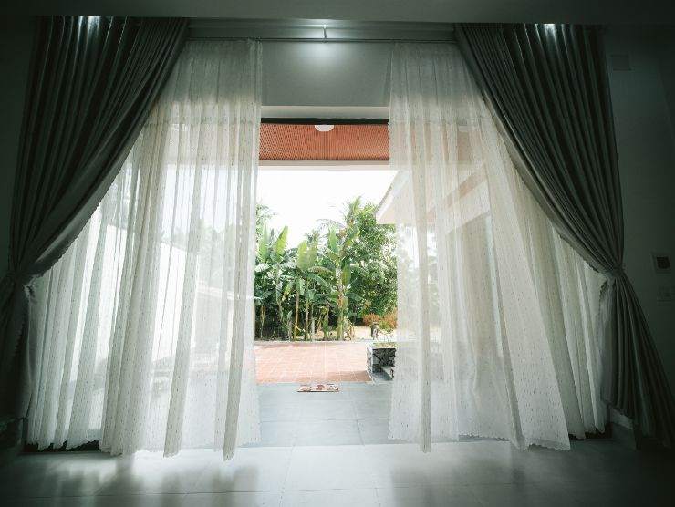 vista di una stanza dal basso con balcone aperto e tende